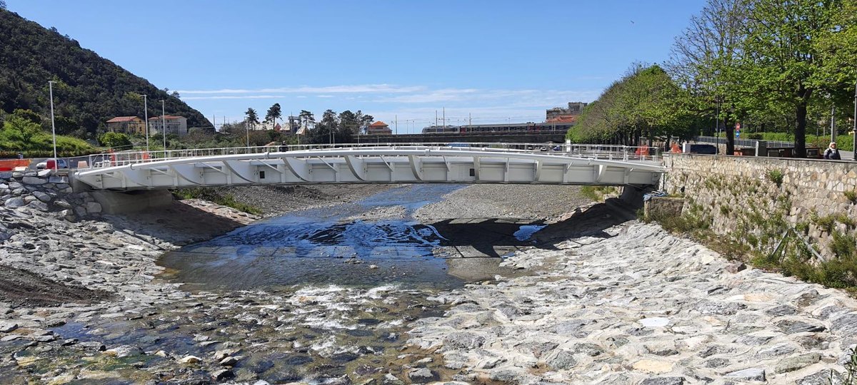 Ponte ad arco in acciaio sopra un torrente
