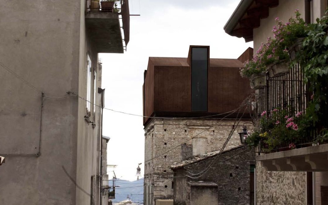 Volume in acciaio corten su edificio storico